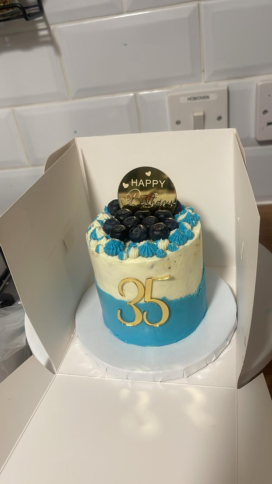 Blueberry birthday cake with blue and white buttercream